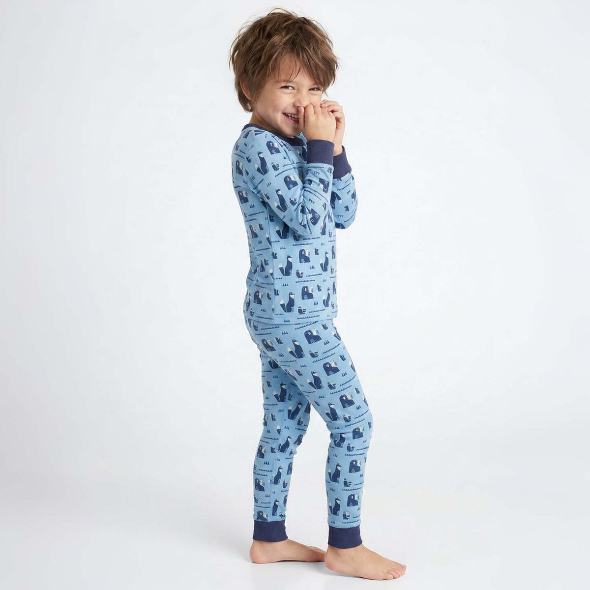 Child wearing blue pajamas with a pattern on a white background