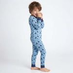 Child wearing blue pajamas with a pattern on a white background