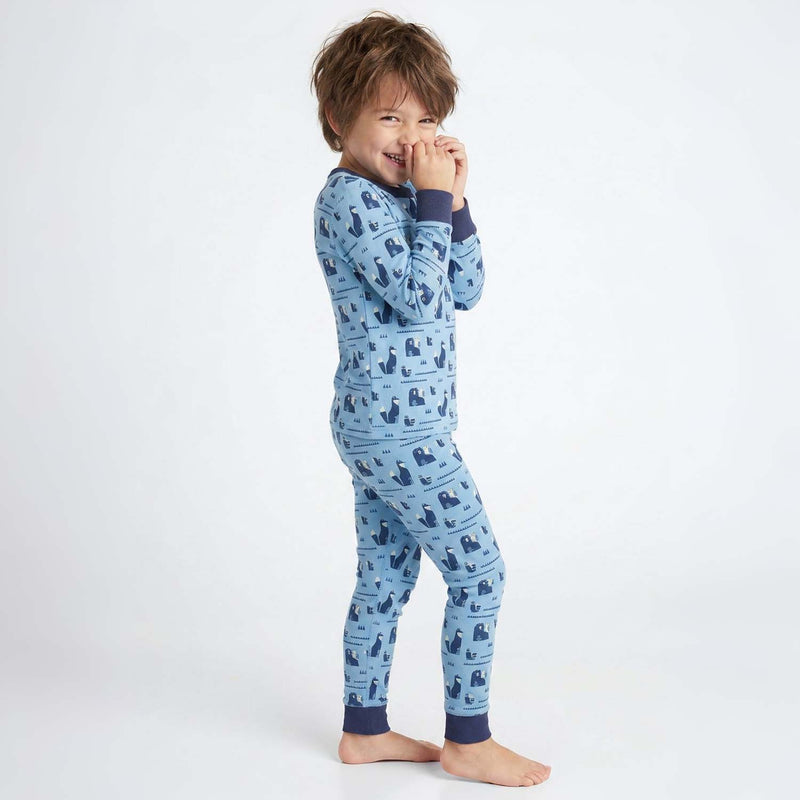 Child wearing blue pajamas with a pattern on a white background