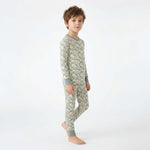 Child wearing a green snake patterned pajama set on a white background