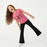 Child wearing a pink t-shirt with a fox graphic design and black flared yoga pants on a white background