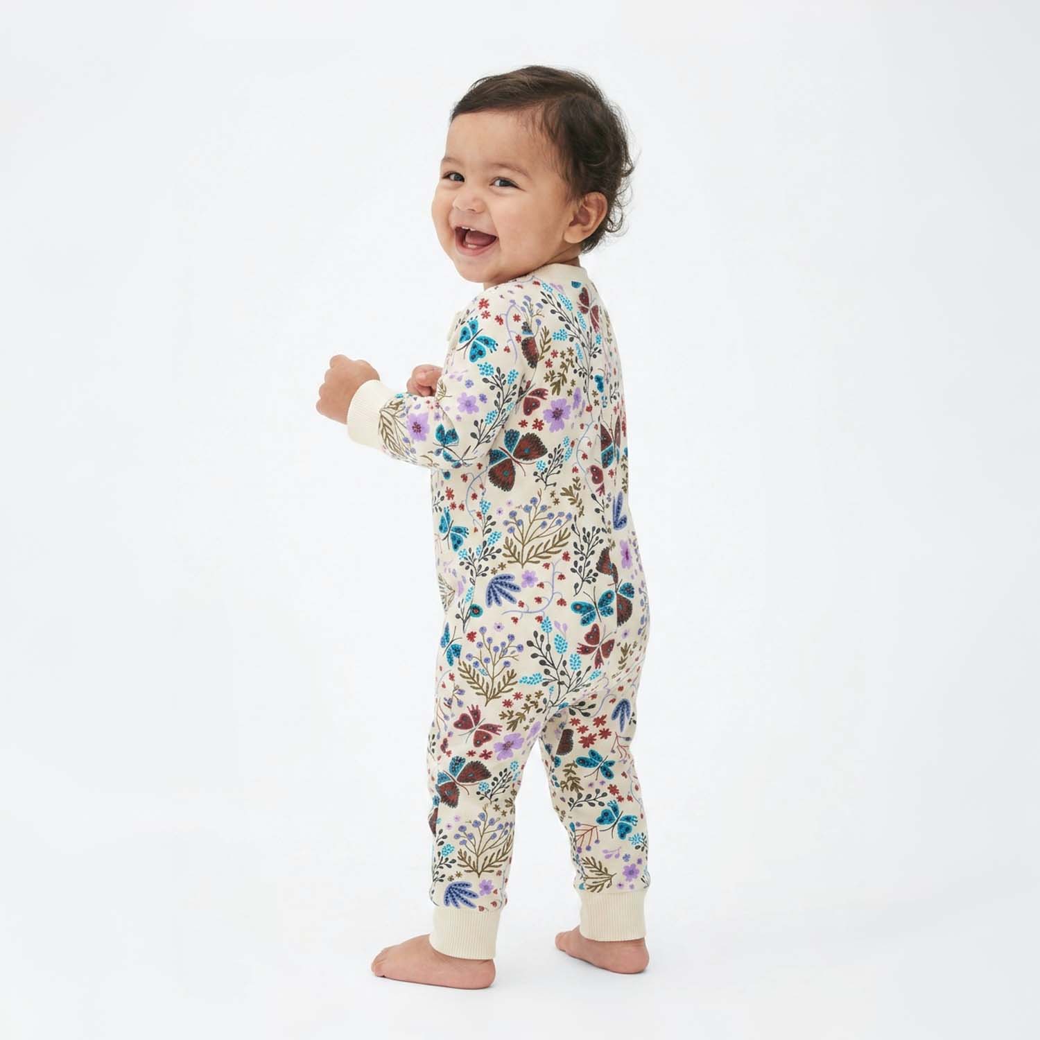 Baby wearing a floral onesie on a white background