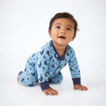 Baby wearing a blue pajama with animal pattern on a white background