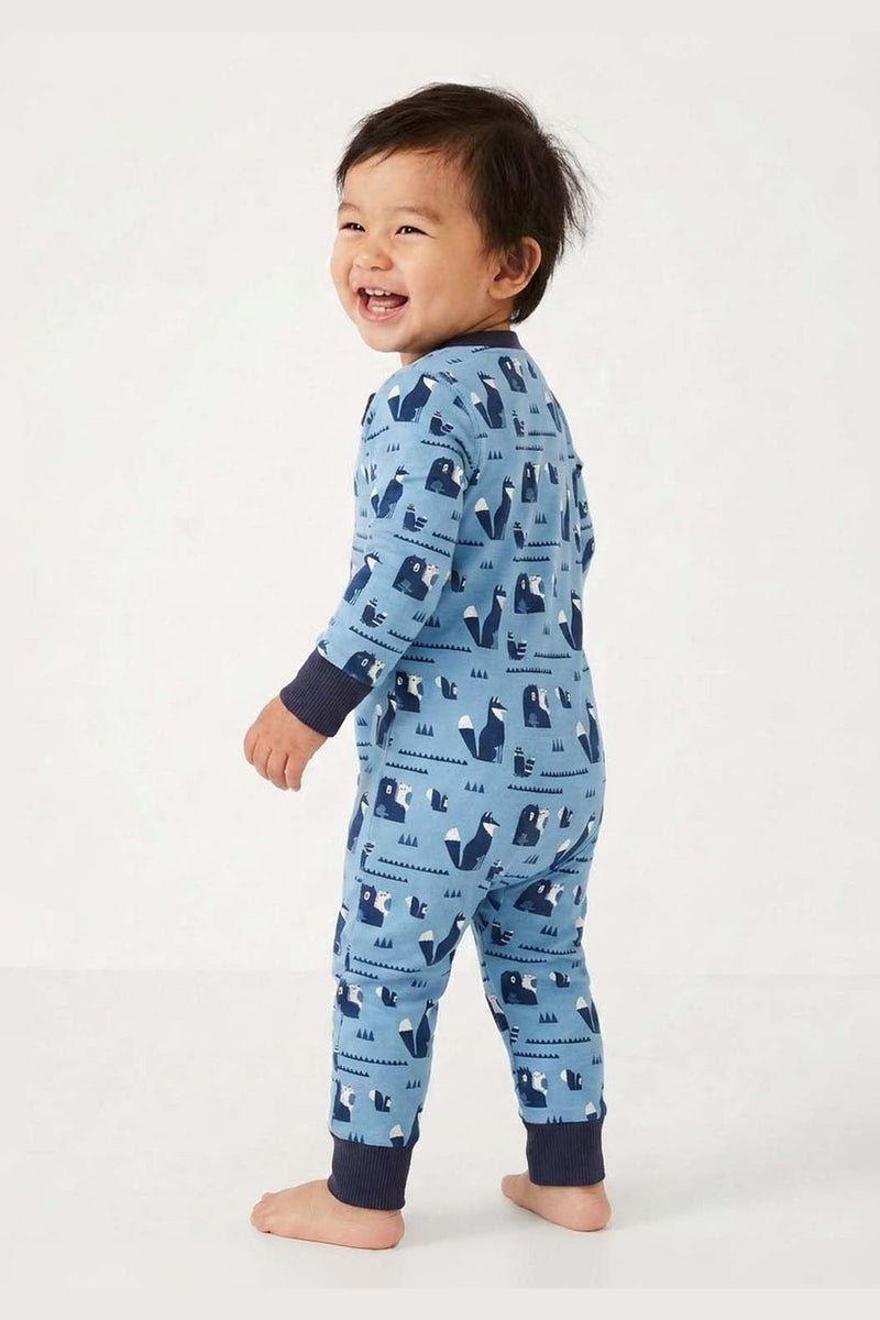 Baby standing wearing a blue pajama with animal pattern on a white  background #bear-venture