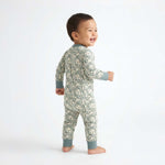 Child wearing a snake print onesie on a white background