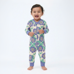 Baby wearing a floral patterned onesie with purple flowers on a white background