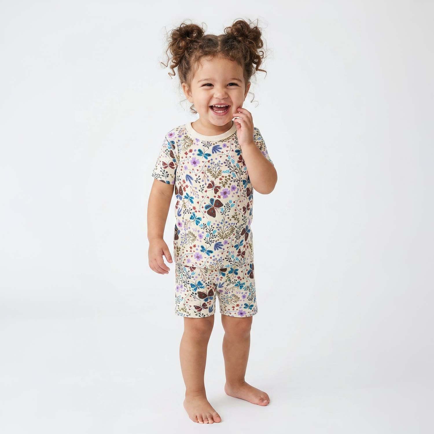 Child wearing floral pajamas on a white background