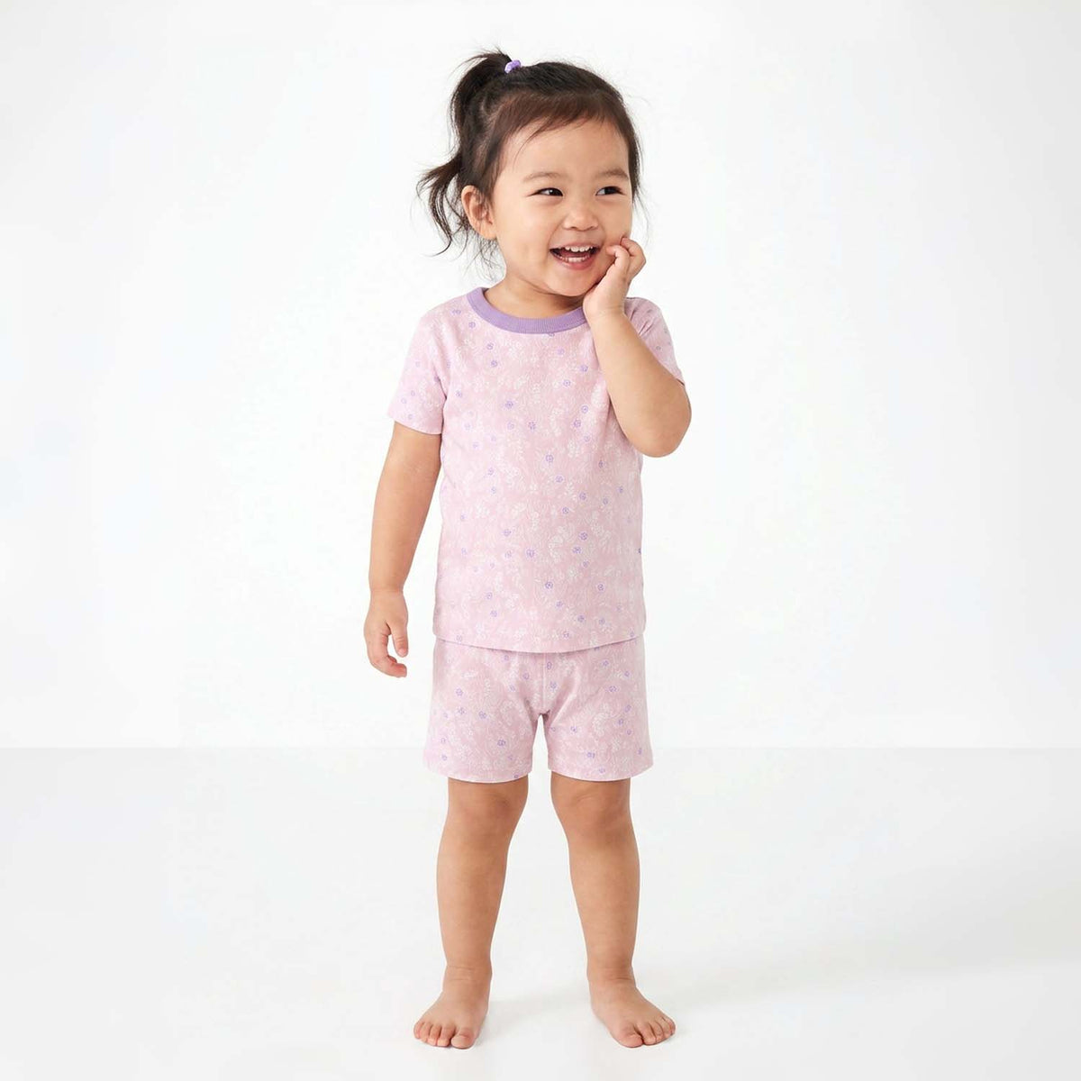 Child wearing pink pajamas with a white background