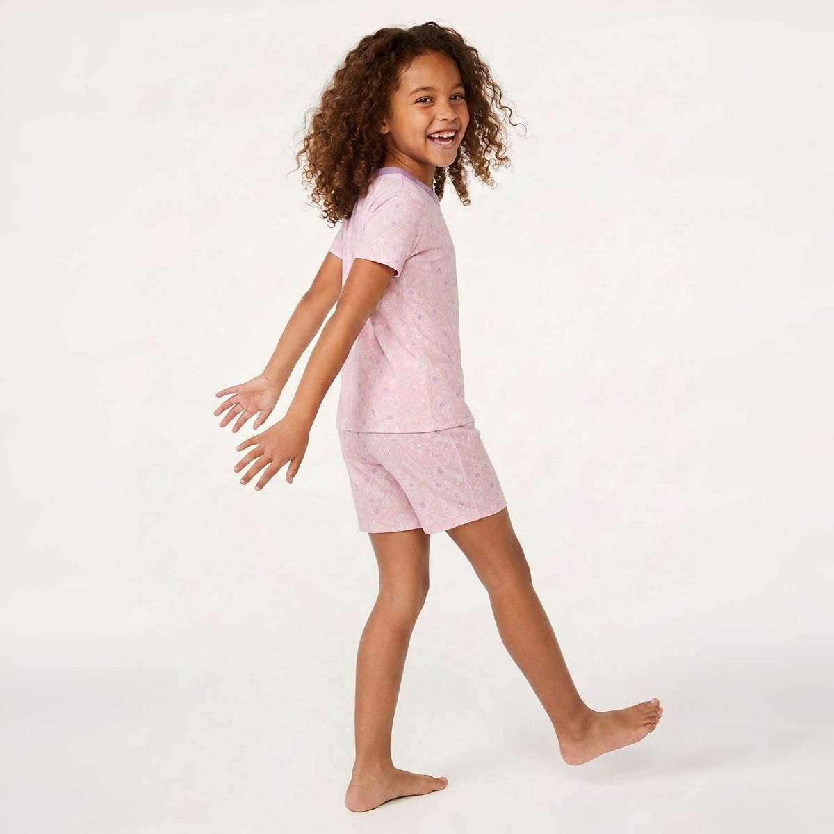 Child wearing a pink pajama set on a white background