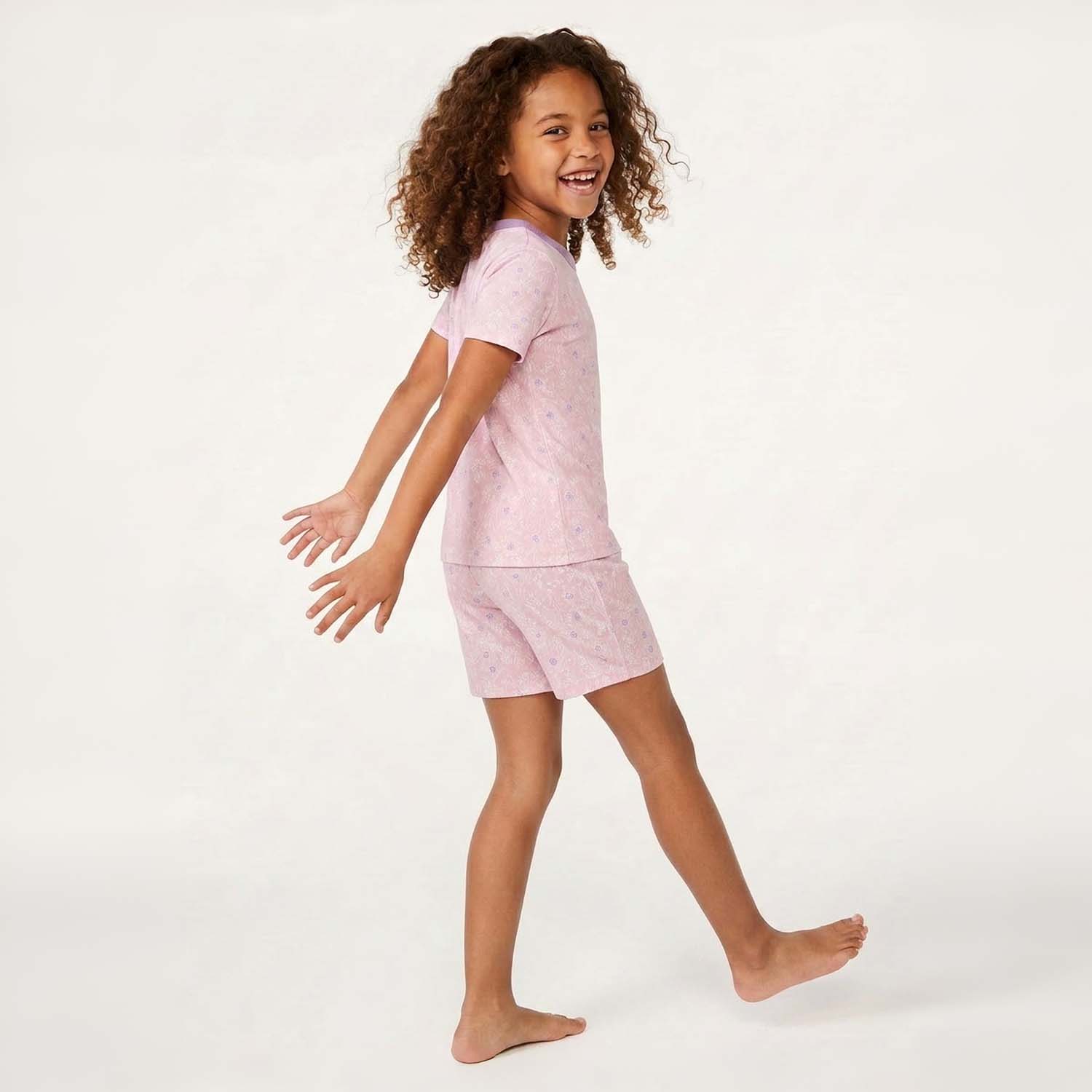 Child wearing a pink pajama set on a white background