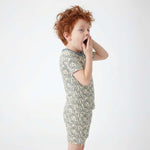 Child wearing a snake print pajamas on a white background