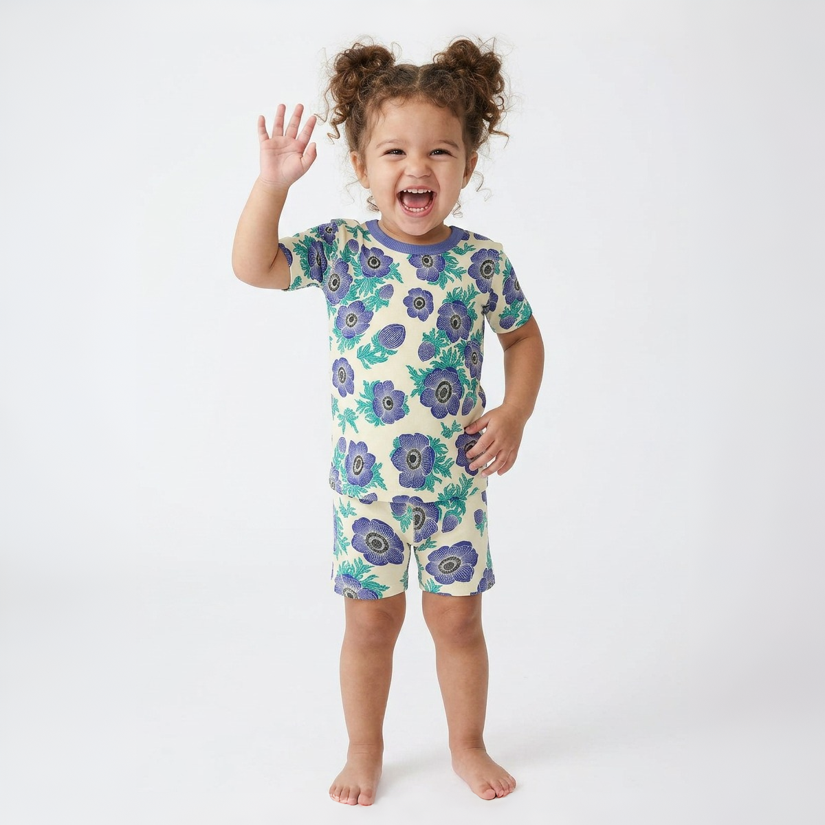 Child wearing a purple floral pajama set on a white background