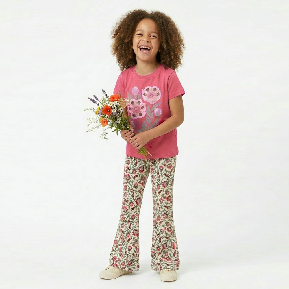 Child wearing a pink shirt with a flower design and floral pants, holding flowers on a white background