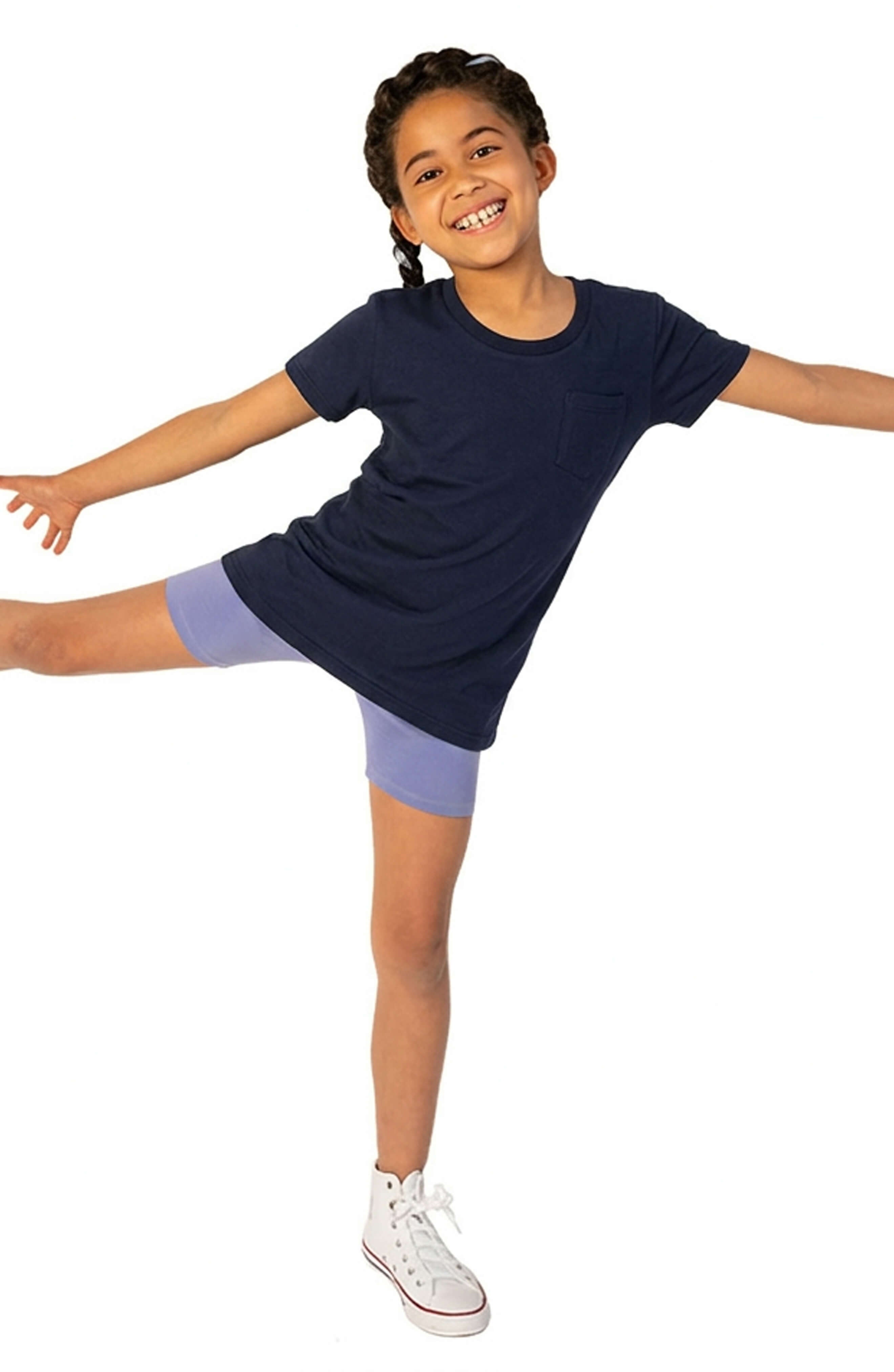 Child wearing a navy blue dress with purple shorts on a white background