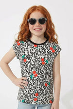 Young girl wearing a leopard print t-shirt with colorful flower patterns on a white background