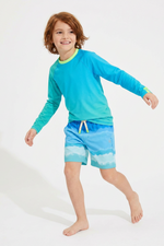 Child wearing a blue long-sleeve rash guard and matching shorts on a white background